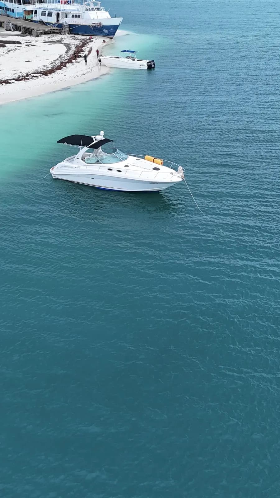 Invitados disfrutando un día privado en yate sobre agua Caribe brillante